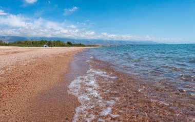 Dağ gölü, temiz şeffaf su. Kıyı şeridi. Kırgızistan, Issyk-Kul Gölü doğal arka plan