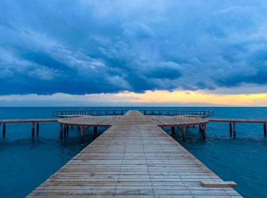 Denizde renkli bir gün batımı. Turuncu güneş ışınlarında dağ gölü. Kırgızistan, Issyk-Kul Gölü. Doğal arka plan. Peyzaj