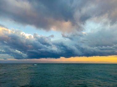 Denizde renkli bir gün batımı. Turuncu güneş ışınlarında dağ gölü. Kırgızistan, Issyk-Kul Gölü. Doğal arka plan. Peyzaj