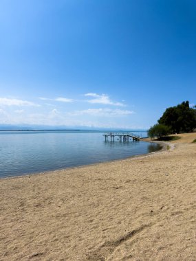 Arka planda görkemli dağlarla Issyk-Kul gölünün sakin su yüzeyi. Kırgızistan 'ın güzel doğal manzarası.