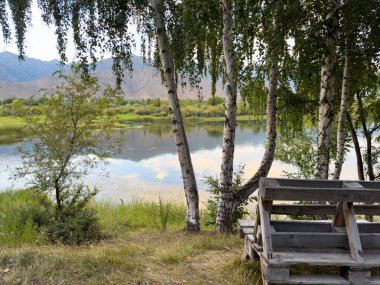 Yeşil vadiler ve görkemli dağlarla çevrili sessiz bir dağ gölü Issyk-Kul. Kırgızistan 'da turizm ve huzurlu dinlenme için mükemmel bir yer.