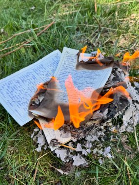 Alevler otları yakarken el yazısıyla yazılmış metinleri içeren defterler.