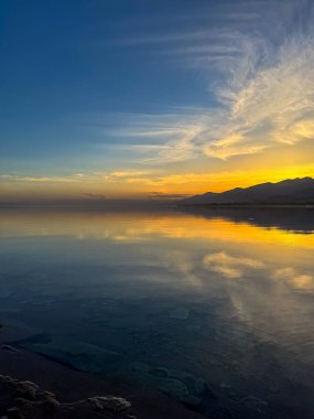 Sessiz dağ gölü, akşam güneşi, Kırgızistan. Gölde durgun su ve dağ yansıması