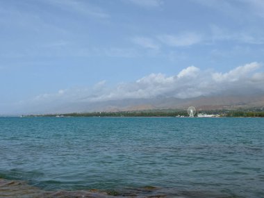 Akşam sakin ve pürüzsüz göl yüzeyinde yumuşak bulutların altında.