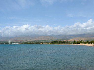 Akşam sakin ve pürüzsüz göl yüzeyinde yumuşak bulutların altında.