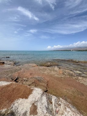 Uçsuz bucaksız gökyüzünün altında Issyk-Kul 'un kayalık kıyısı ve berrak suyu.