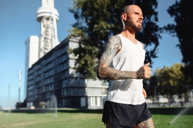 Atletik sakallı, beyaz, beyaz bir adam sabah şehir dışında koşuyor sağlıklı atletik erkek sporcu.