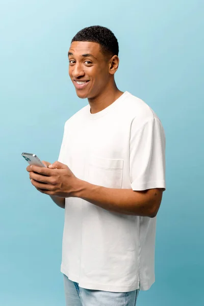 Vertikální Portrét Veselého Afroameričana Bílém Tričku Mobilním Telefonem Úsměvem Chlápek — Stock fotografie