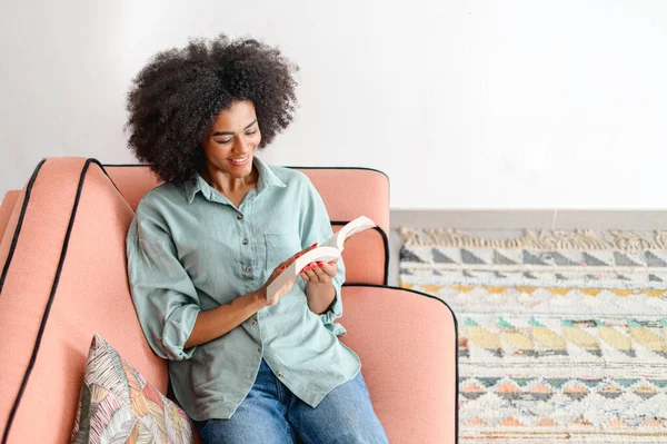 Serene Young Black Woman Enjoying Reading Book Lying Comfy Sofa — Stock Photo, Image