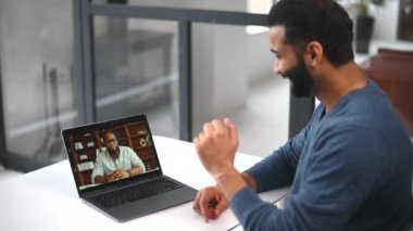 Video toplantısına katılan iki farklı erkek arkadaş. Sanal konferansta çok ırklı iş ortakları vardı. Hintli erkek öğrenci Afrikalı öğretmenden online dil dersleri alıyor.