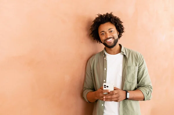 Smiling African American Businessman Smartphone Hand Looks Camera Standing Indoor — Stock Photo, Image