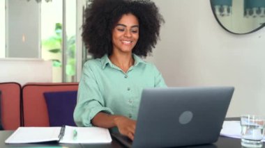 Cheerful African-american female employee involved virtual meeting working remotely from home office, black woman using laptop for video call, greeting participants and talking online
