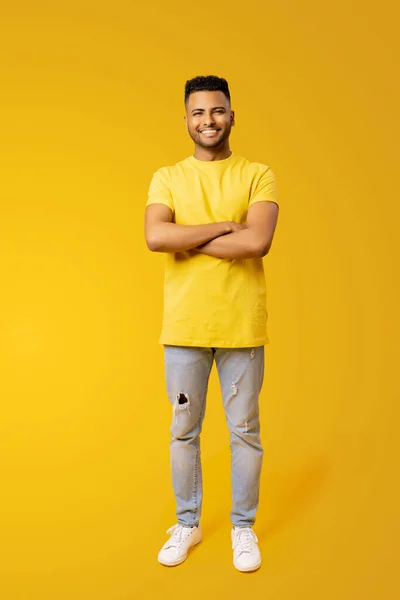 图为身穿黄色T恤的年轻印度男子20多岁 手牵手 头戴纯黄背景的全长肖像画 男外国学生 — 图库照片