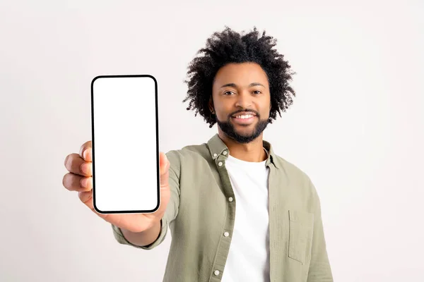 Nadšený Veselý Afroameričan Kudrnatý Mladý Muž Ukazuje Smartphone Prázdnou Obrazovkou — Stock fotografie