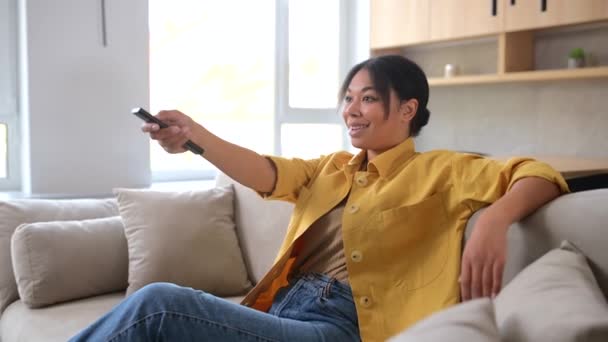 Mulher Multirracial Jovem Feliz Assistindo Programas Televisão Senta Sofá Confortável — Vídeo de Stock