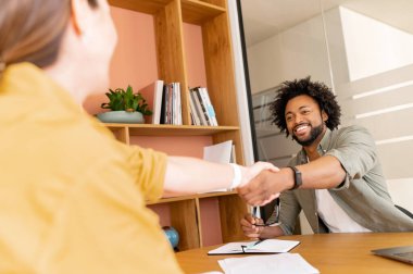 İki iş adamı masada oturuyor ve işbirliği işareti olarak el sıkışıyorlar. Çeşitli kadın ve erkek ofis çalışanları birbirlerini selamlıyorlar. İş ortakları bir anlaşma yaptı, işe alım kavramı.