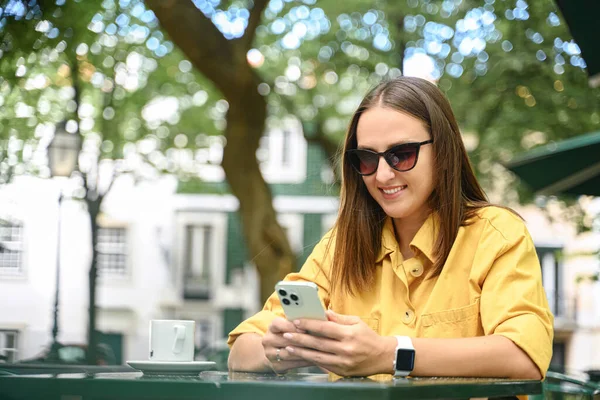 Приваблива Безтурботна Молода Жінка Сонцезахисних Окулярах Використовуючи Смартфон Відкритому Повітрі — стокове фото