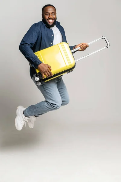 Fröhlicher Afroamerikanischer Typ Springt Mit Einem Gelben Koffer Spielt Auf — Stockfoto