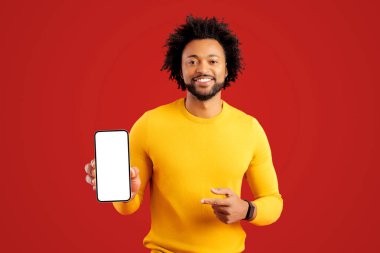 Heyecanlı yakışıklı sakallı adam, kırmızı ekranda boş boş ekranlı akıllı telefonu işaret ediyor, mutlu adam mobil uygulama sunuyor, en iyi anlaşmayı gösteriyor, kopyalama alanı, şablon
