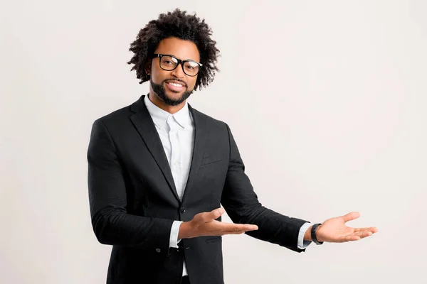 身穿黑色西服的非裔美国男性创业者 经理或企业主 两只手合十 为某事物做广告或代表某事物 孤立地复制空间 微笑着 — 图库照片