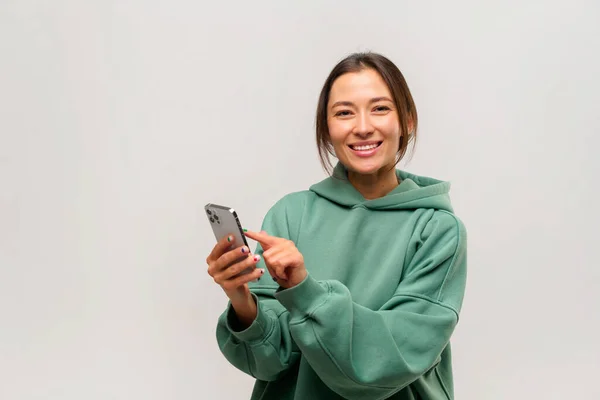 Mujer Morena Asiática Satisfecha Sosteniendo Teléfono Inteligente Las Manos Charlando — Foto de Stock