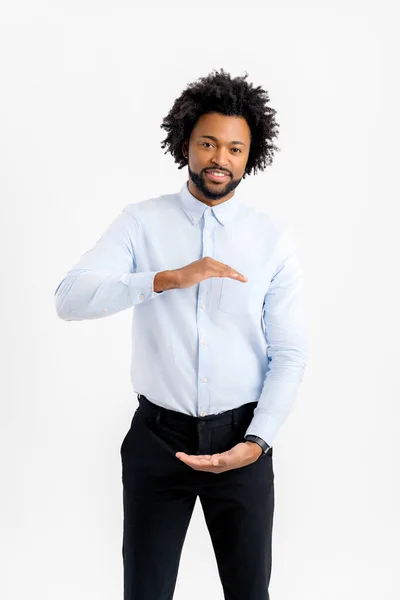 白の正式なシャツを身に着けている現在ハンサムなアフリカ系アメリカ人の男性は 大小のサインを示す手でジェスチャー記号を測定します カメラを見て微笑んだ 概念の測定 — ストック写真