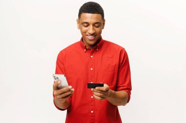 Ekrana bakarken cep telefonuyla uzun zamandır beklenen alışverişi yapan bir erkek. Orta Doğulu mutlu adam internetten yemek sipariş ediyor. Adam alışveriş için akıllı telefon ve kredi kartı kullanıyor.