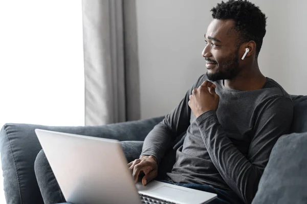 생각깊은 아프리카 미국인 남자는 노트북을 앉아서 과즐거운 속에서 잃어버린 바라봅니다 — 스톡 사진