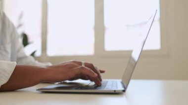 Afro-Amerikalı bir kadının dizüstü bilgisayar kullanırken çekilmiş resmi, klavyede kadın çalışan, e-postalarına cevap veren, çok ırklı kadın serbest çalışan, iş arkadaşlarıyla uzaktan çalışan