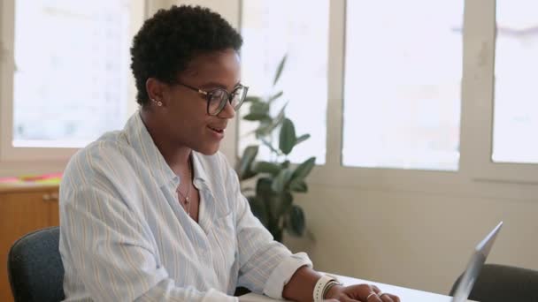 以时髦的发型与网上听众交谈 使用笔记本电脑 举行虚拟会议 女学生参加研讨会 网络研讨会 挥挥手打招呼等方式来吸引快乐的非洲裔美国女青年 — 图库视频影像