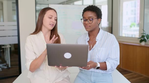 两名女同事讨论新项目 女商人在办公室里一起使用笔记本电脑 经理向员工解释任务 团队协作与合作 — 图库视频影像