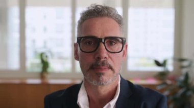 Neşeli ve dingin modern iş adamının yakın plan portresi şık giyinmiş, şık gözlükler takmış, 60 'ların beyaz saçlı üst düzey yöneticisinin vesikalığı dişlek tebessümle kameraya bakan lider.