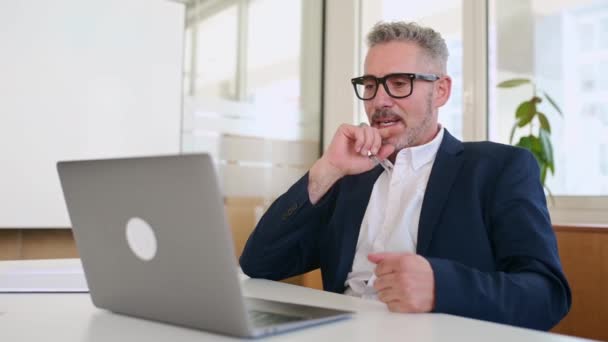 快乐而成熟的50多岁的商人在网上聊天 在他办公室的笔记本电脑上使用虚拟连接应用程序 在视频通话中 成熟的白发男性专业老板 穿着正装交谈 — 图库视频影像