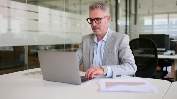 Skoncentrowany Starszy Mężczyzna Pracownik Biura Robi Rozgrzewkę Podczas Pracy Laptopem — Wideo stockowe