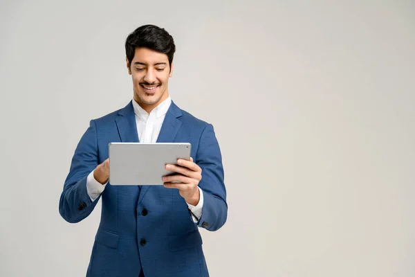 The professional stands with a tablet, his smile and attentive look reflecting an individual adept in digital tools, perfect for representing digital marketing or business innovation, isolated