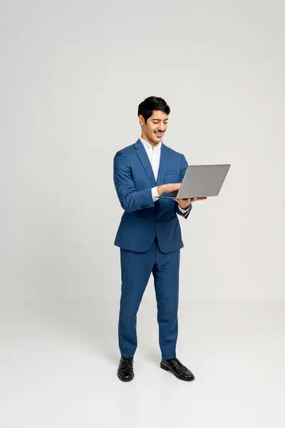 Professional Man Blue Suit Stands Confidently Laptop His Posture Relaxed — Stock Photo, Image