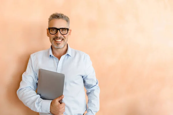 Relaxed Yet Confident Mature Businessman Casually Holds His Laptop Standing — Stock Photo, Image