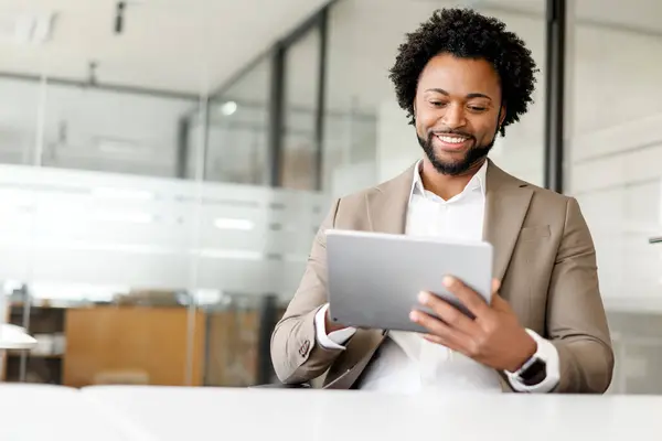 Zawartość Afroamerykanin Biznesmen Używa Tabletu Biurze Jego Uśmiech Odzwierciedla Udaną — Zdjęcie stockowe