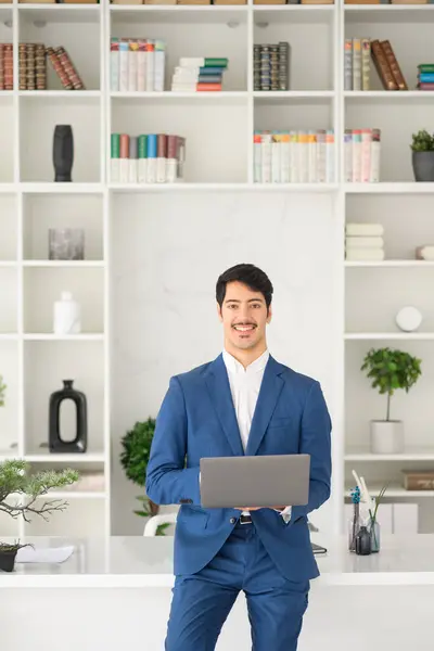 Smilende Latinamerikansk Forretningsmand Stilfuld Blå Dragt Står Med Bærbar Computer - Stock-foto