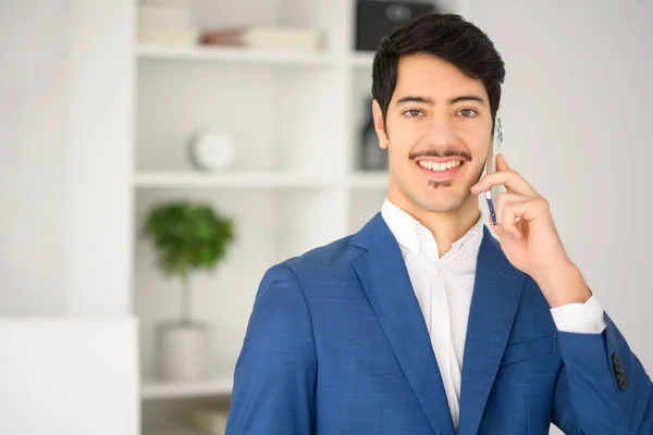 Charismatic Hispanic Businessman Blue Suit Engaging Conversation Smartphone Set Modern — Stock Photo, Image