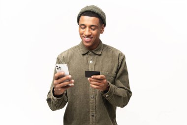 Neşeli Orta Doğulu adam online alışveriş için akıllı telefon ve kredi kartı kullanıyor. Mutlu adam internetten yemek sipariş ediyor. Erkek, uzun zamandır beklenen cep telefonunun parasını ödüyor.