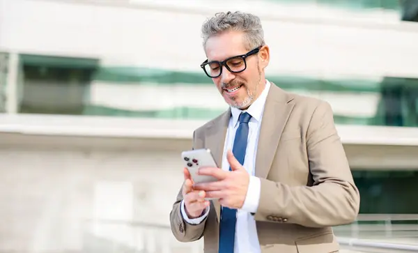 Intelligent Senior Businessman Smiling Looks His Smartphone Reviewing Successful Transaction — Stock Photo, Image