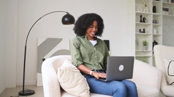 Glad Afroamerikansk Kvinna Arbetar Bekvämt Sin Bärbara Dator Hemma Utstrålar — Stockvideo