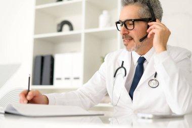 Konuşmanın ortasında yakalanan bu deneyimli doktor özenli tavrı, kliniğinden telefonla aranırken hasta bakımında iletişimin önemini aktarıyor..