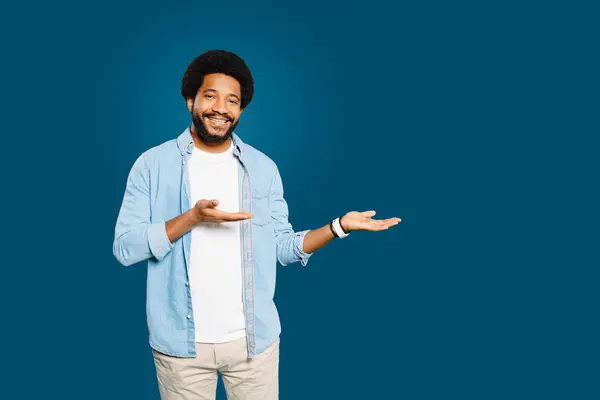 Charming Man Curly Afro Hair Gesturing Aside Open Palm Offering — Stock Photo, Image