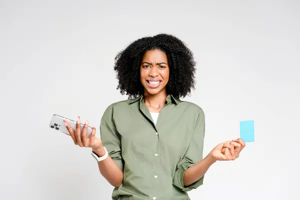 Confused African American Woman Holds Smartphone Credit Card Her Expression — Stock Photo, Image