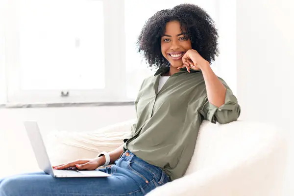 Una Mujer Afroamericana Alegre Disfruta Momento Relajación Sofá Con Portátil —  Fotos de Stock