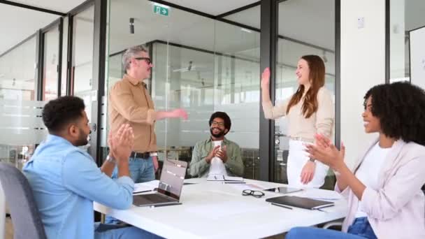 간결한 사무실 분위기에서 동료들은 공유하고 박수와 미소로 성공적인 순간을 축하하며 — 비디오