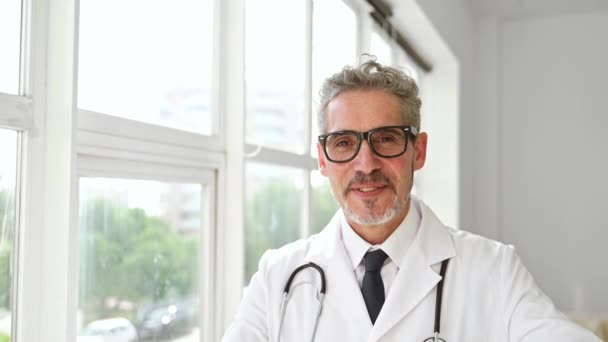 Médico Sênior Com Sorriso Quente Vestindo Estetoscópio Tirando Óculos Capturado — Vídeo de Stock