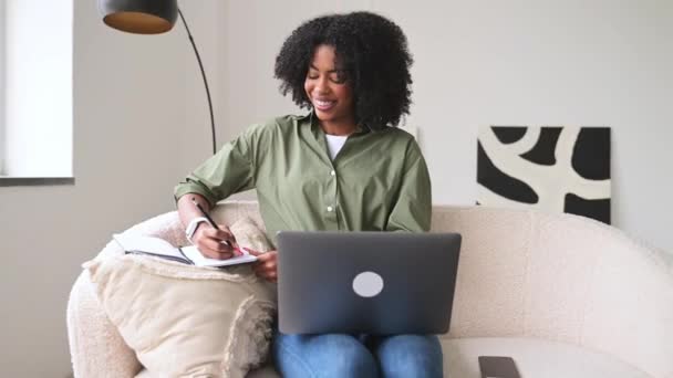 Seorang Wanita Afrika Amerika Yang Ceria Bekerja Pada Laptop Sambil — Stok Video